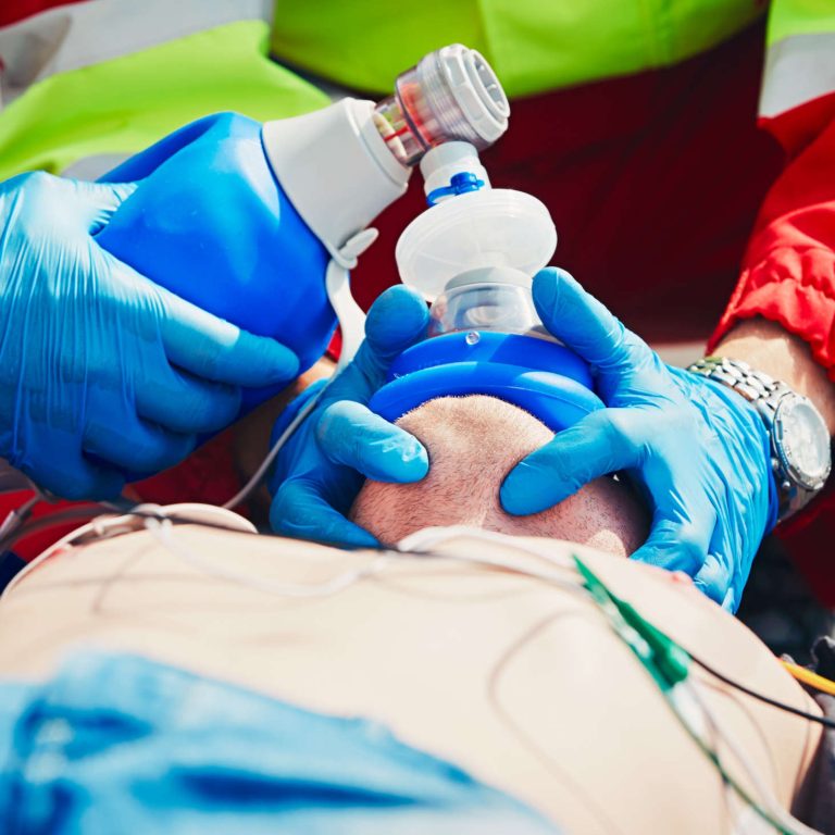 Cardiopulmonary resuscitation. Rescue team (doctor and a paramedic) resuscitating the man on the street.